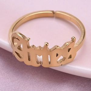 Macro view of gold-plated Aries zodiac ring with gothic lettering on a polished band