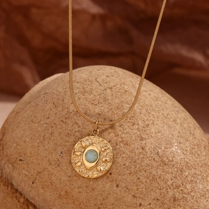 Detail of 18K gold snake chain with hammered eye pendant and light blue amazonite stone