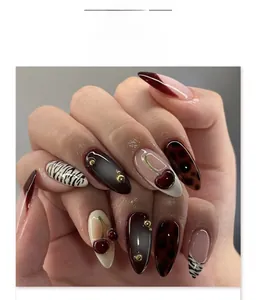 Vue détaillée de faux ongles ovales avec texture écaille et motifs cerise en 3D