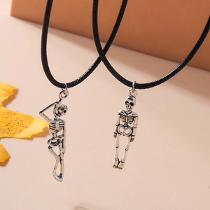 Detail of silver skeleton couple pendants with black cords and seasonal maple leaf decor