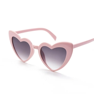 Detail view of heart-shaped sunglasses with pink frames and purple gradient lenses