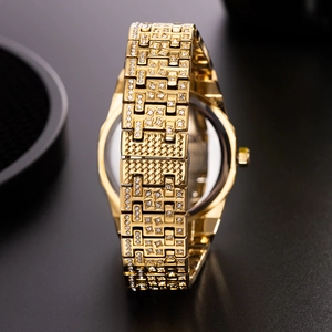 Close-up of the gold metal case back and crystal-studded links of a luxury watch