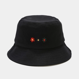 Detailed close-up of three small flower embroideries on black cotton bucket hat