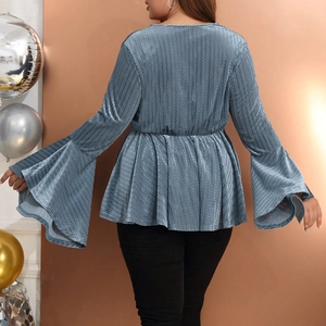 Detail view of the back of a blue flare sleeve top featuring wavy textured metallic fabric
