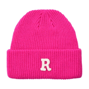 Detailansicht der rosaroten Strickmütze mit weißem Frottee-Buchstaben-R-Aufnäher