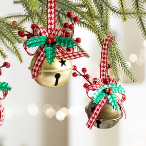 Christmas bow bells with holly leaves hanging on a tree with festive light bokeh