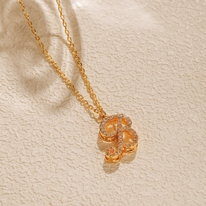 Macro detail of gold-plated letter B pendant with shimmering cubic zirconia inlay