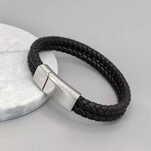 Detailed view of black braided leather bracelet with a polished silver magnetic clasp