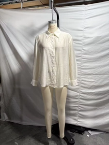 Detailed view of textured white button-down shirt fabric on a full-body mannequin