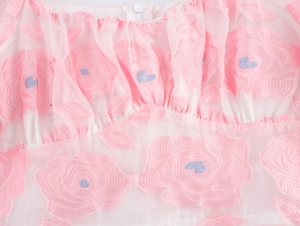 Detail of pink tulle fabric with floral embroidery, pleated neckline and front zipper closure