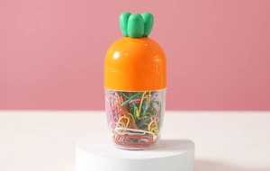 Detailed view of carrot-shaped paper clip holder with colorful metal clips inside