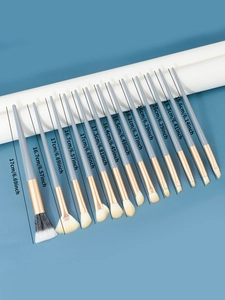 Detail of 14-piece makeup brush set with matte grey handles and gold ferrules in various sizes
