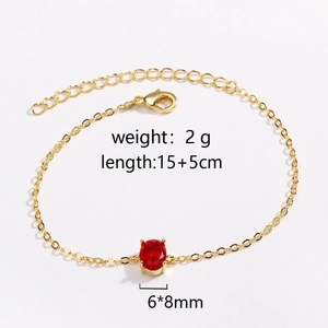 Detail view of a 15+5cm adjustable gold chain bracelet with a 6x8mm red oval gemstone
