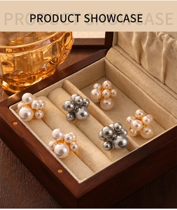 Macro shot of white and grey shell pearl flower earrings in a wooden jewelry box display