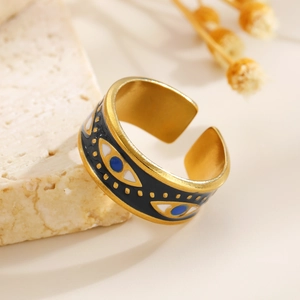 Close-up of vintage gold open ring with black enamel and blue evil eye charms