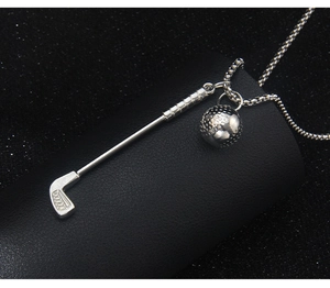 Macro shot of silver golf club and ball pendant with intricate metallic textures