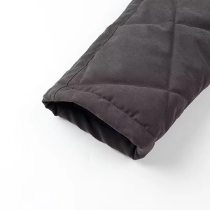 Detailed macro view of the quilted diamond pattern on black cotton jacket sleeve cuff