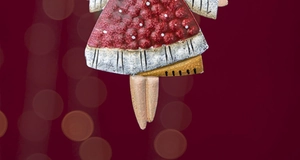 Close-up of red metal angel ornament with white polka dots and vintage painted finish
