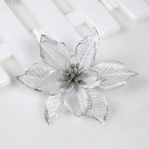 Macro view of a 15cm silver glitter Christmas flower on a white wooden background