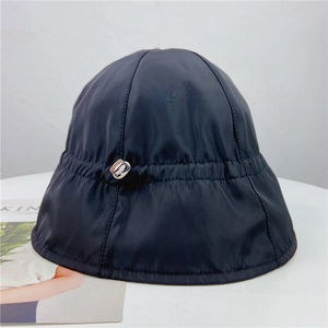 Detail of black bucket hat with metallic toggle adjustment and lightweight fabric