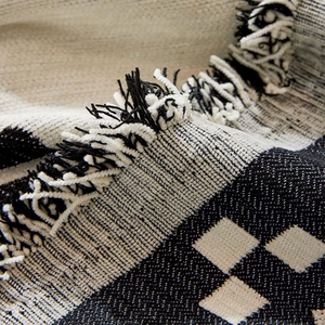 Bohemian chenille sofa cover with black and white geometric patterns and tassel edges