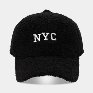 Detailed view of the fuzzy black Sherpa fabric and white NYC embroidery on the baseball cap