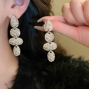 Vintage textured metal teardrop earrings featuring a geometric baroque design