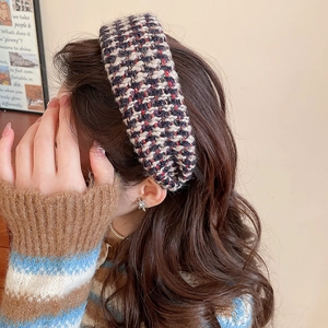 Close-up of a wide tweed headband in brown and cream, showing texture on wavy hair