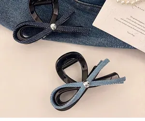 Détail de pinces à cheveux en denim bleu foncé et clair avec boutons argentés