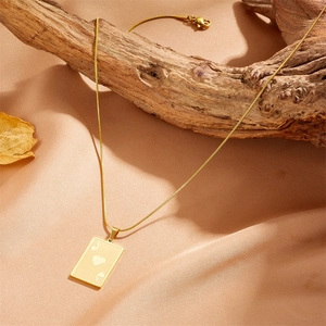 Golden Ace of Hearts poker pendant necklace with snake chain on rustic wood background
