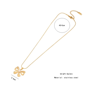 Macro view of gold stainless steel bow pendant necklace with pearl detailing and size specs
