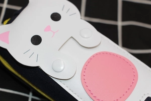 Detail of cute cat pencil case showing navy canvas material and white decorative buttons