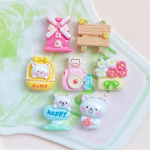 Detailed close-up of colorful resin charms including windmill camera and bear accessories