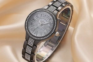 Gros plan d'une montre à quartz noire ornée de strass brillants et de chiffres romains