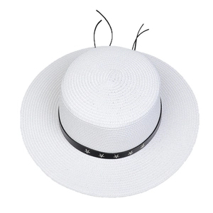 Detail of white straw hat featuring black leather band with silver star metal rivets