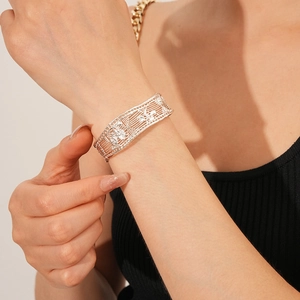 Detail of silver hollow mesh wide bangle featuring intricate woven patterns and butterfly