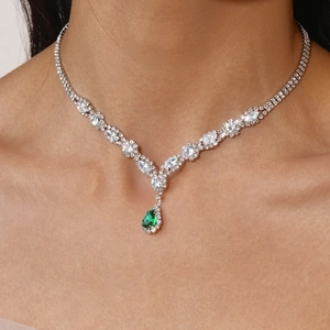 Detail of luxury necklace with green pear-shaped zircon and sparkling pavé diamonds