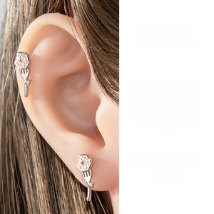 Detail showing a silver fork and pink donut cartilage stud with cubic zirconia stones