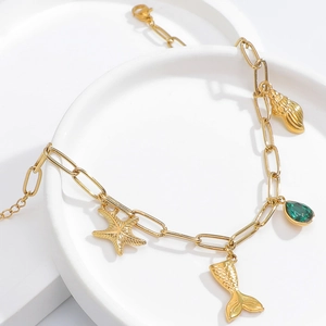 Detailed macro shot of 18K gold-plated ocean-themed bracelet with starfish and shell charms