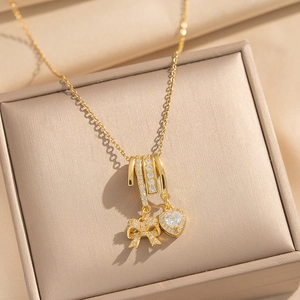Elegante goldene Halskette mit Schleife und Herzanhänger mit Kristallen auf Schmuckbox