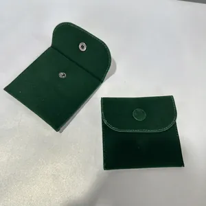 Detail view of dark green velvet jewelry pouches with metallic snap button closure