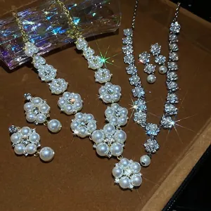 Elegant pearl and crystal flower jewelry set with earrings and necklaces on velvet tray