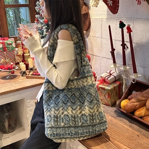 Close-up of Fair Isle plush tote bag with blue and grey geometric patterns in festive setting