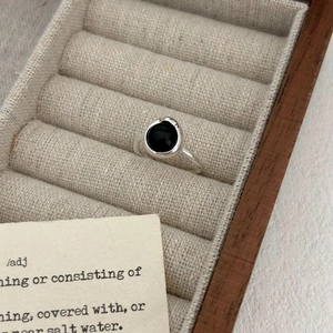 Minimalist S925 sterling silver ring featuring a round black agate stone on gray velvet