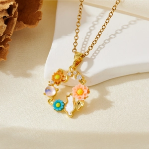 Collier doré avec pendentif couronne de fleurs lapin de jardin sur décor en pierre