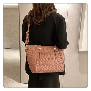 Detail der gewebten Ledertasche in Rosa mit verstellbarem Gurt am Model getragen