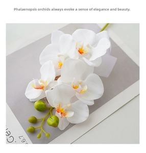 Macro view of white artificial orchid petals with yellow center on gray background