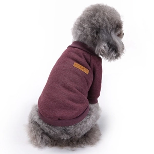 Detail of burgundy knit dog sweater featuring back leather label and classic warm texture