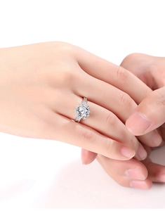 Detailed close-up of a silver snowflake ring with a large moissanite center stone on hand