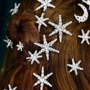 Detail showing crystal-encrusted star and moon hair pins on brown hair style